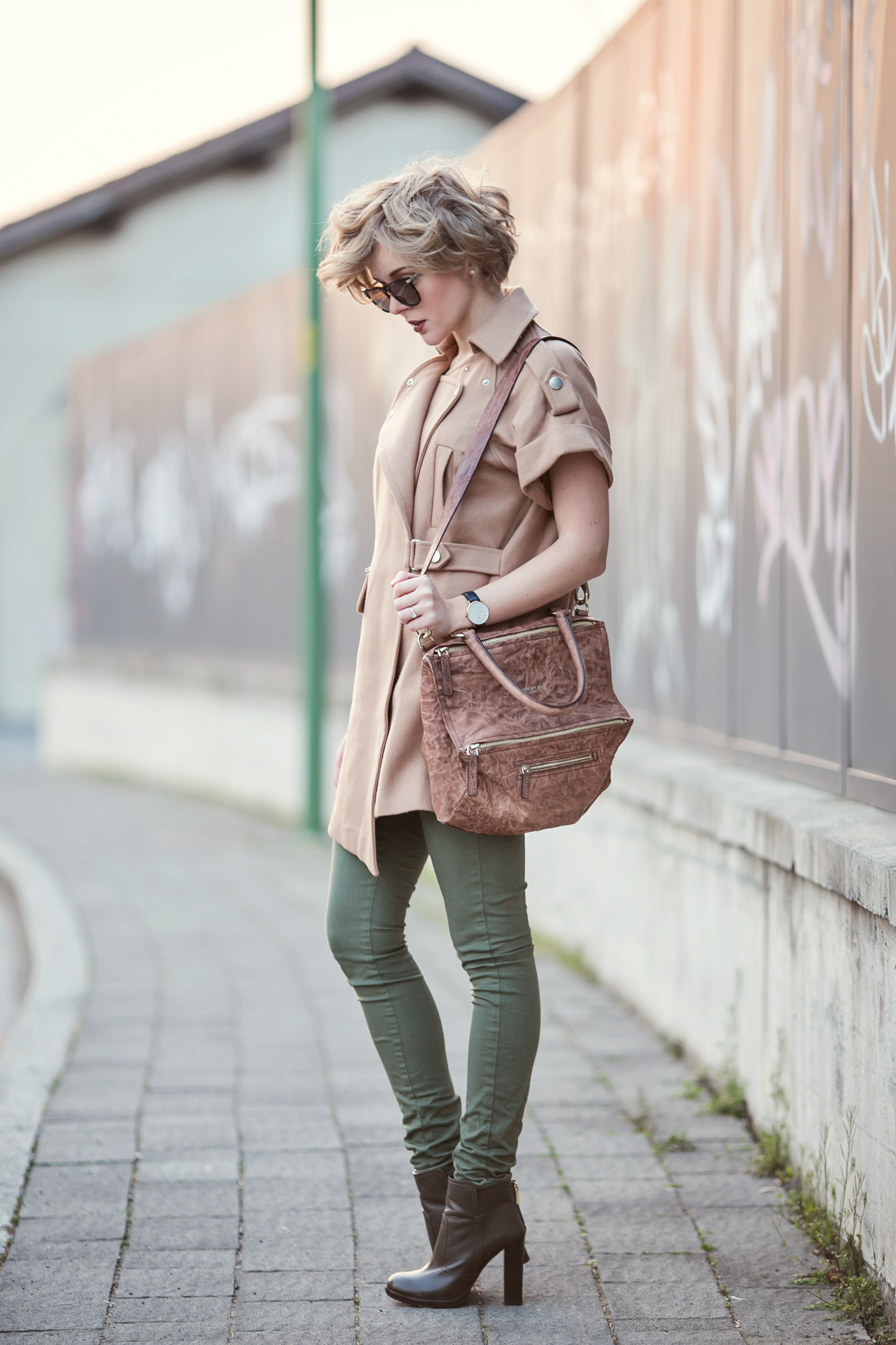darya kamalova from thecablook com is doing a street style outfit wearing chicwish sleveless coat and givenchy pandora bag with tory burch booties ans asos green skinny pants on the sunset copy